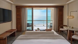A hotel room with a large bed, a desk, a chair, a television, and a view of the sea. - Park Hyatt Riviera Maya - All Inclusive (Puerto Morelos)