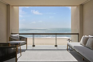 A balcony with a view of the beach, a sofa, a table, and a chair. - Park Hyatt Riviera Maya - All Inclusive (Puerto Morelos)