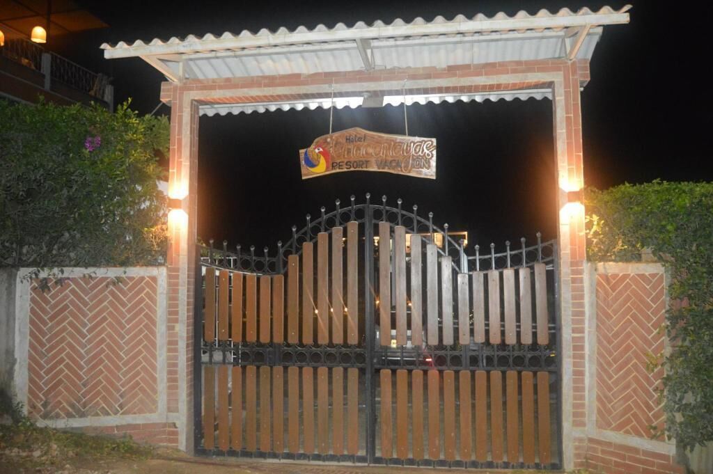 A gated entrance to a hotel with a sign above the gate.