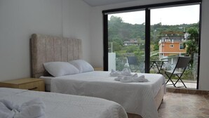 A hotel room with two beds, a large window, and a balcony with a view of the surrounding area. - hotel guacamayas resort vacation (La Mesa)