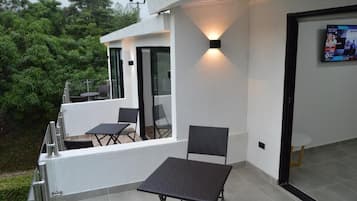 Habitación triple Deluxe, balcón, vista al jardín | Terraza o patio
