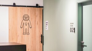 A wooden door with a 'Female Only' sign and a figure symbol, and a wall with 'Dream Dorm 01' and 'Dream Dorm 02' signs. - Dream Factory Hostel Melk (Melk)