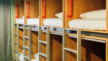 Bunk beds with storage shelves and red handles, arranged in a row.