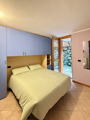 Een slaapkamer met een bed, een kledingkast en een badkamer.