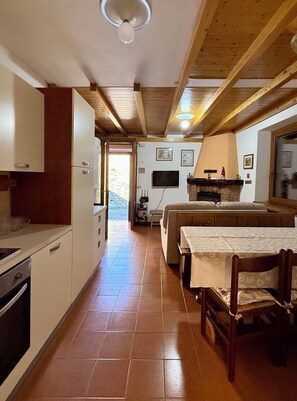 Une cuisine équipée d’une cuisinière, de placards et d’un coin repas avec une table et des chaises.