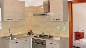 Una cocina compacta con estufa a gas, horno y lavaplatos.