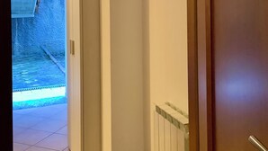 A hallway with a radiator, a door, and a wall-mounted hook. - Quater Pis - Casa in Scalve (Colere)