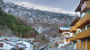 A mountain village with wooden buildings, a snow-covered mountain, and a clear sky. - Quater Pis - Casa in Scalve (Colere)