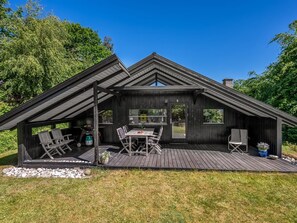 A modern cabin with a deck, outdoor seating, and a large window. - "Lasse" - 550m from the sea by Interhome (Knebel)