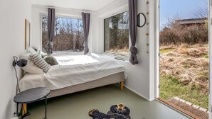 Una camera da letto con un letto, un comodino e vista sull'esterno.
