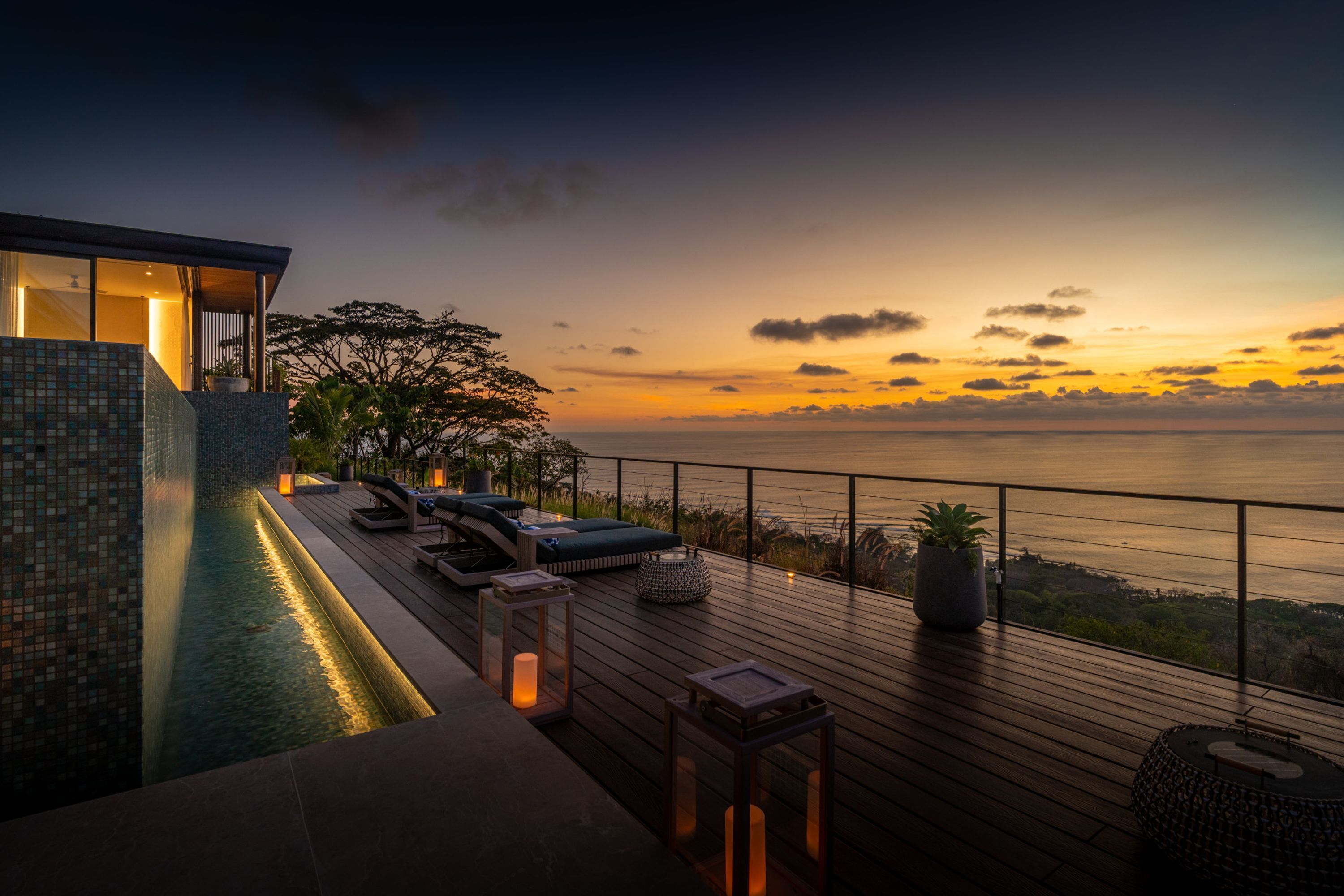 Eine moderne Außenterrasse mit Pool, Lounge-Bereich und Meerblick.