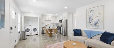 A modern apartment with a kitchen, dining area, and living room.