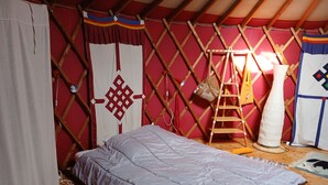 Ein Zimmer mit einem Bett, einer Leiter und einer hängenden Tasche.