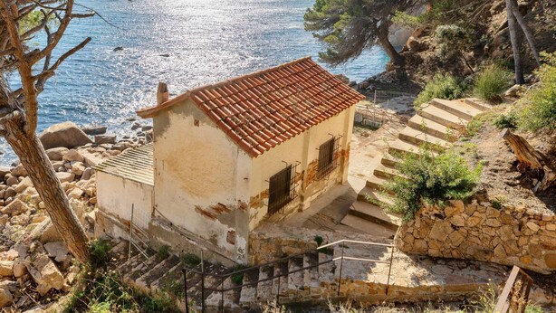 A coastal building with a tiled roof, stone steps, and a view of the sea. - Juliola CostaBravaSi - Pool, AC, beach 200 m away (Sant Feliu de Guíxols)
