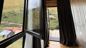 A room with a wooden ceiling, large windows, and a view of a hillside. - Gorgeous 1-bedroom cabin in peaceful Juta for a cozy escape (Juta)