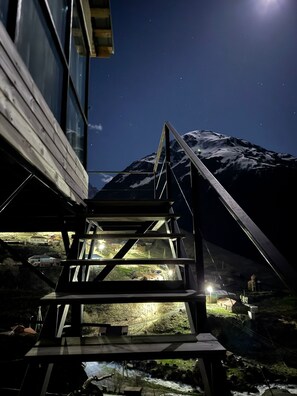 Una escalera conduce a un edificio con vistas a la montaña de noche.