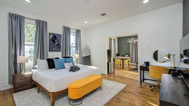 Une chambre moderne avec un grand lit, des tables de chevet, un bureau et une chaise.
