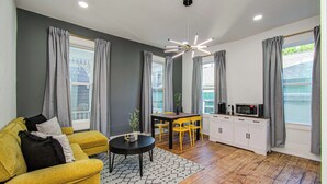 Un salon moderne comprenant un canapé, une table basse, une table à manger et un coin cuisine.