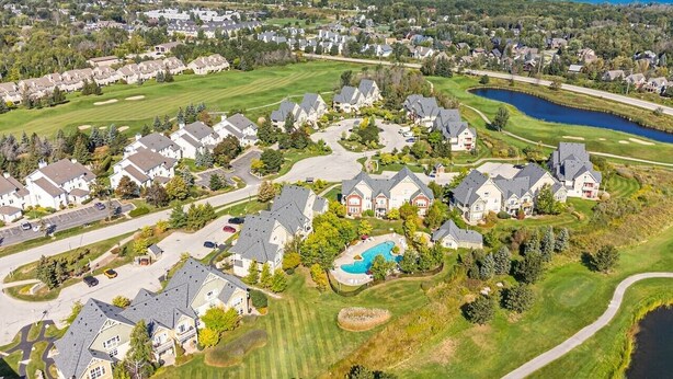 Una zona residenziale con case, una piscina e un campo da golf.