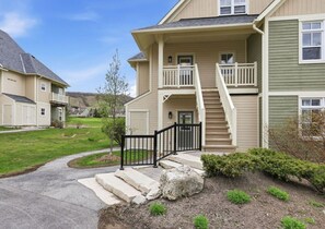 A two-story residential building with a front porch, a staircase, and a driveway. - Birdie’s Eye View: Steps to Village & Golf (The Blue Mountains)