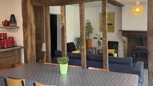 Un comedor con mesa, sillas y una planta en maceta.