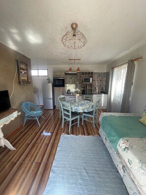 A compact living space with a kitchenette, dining area, and a bed. - Rancho Elquino (Vicuña)