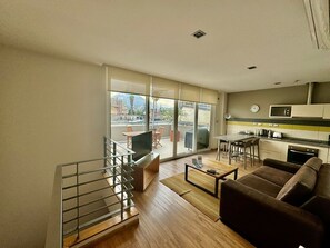 Eine moderne Wohnung mit Balkon, Essbereich, Küche und Wohnzimmer.