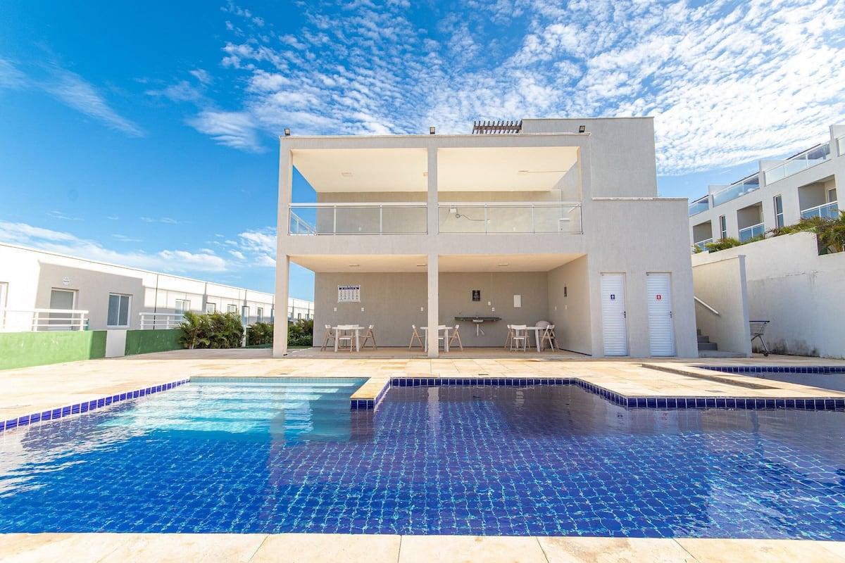 Ein modernes Gebäude mit Pool, Außenbereich und blauem Himmel.