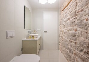 Ein Badezimmer mit Toilette, Waschbecken, Spiegel und einer Tür.