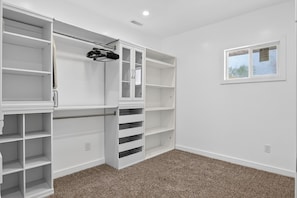 A room with a built-in closet, a window, and a carpeted floor. - Spacious 6-bedroom house in enchanting Detroit with AC (Detroit)