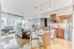 Un appartement moderne comprenant un coin repas, une cuisine et un espace de vie.
