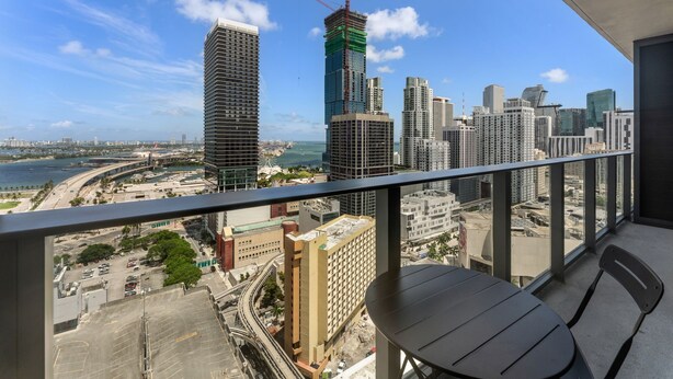 Un balcone con vista sullo skyline cittadino, che comprende grattacieli e una passeggiata sul lungomare.