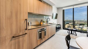Una cucina moderna con mobili in legno, forno integrato e un'ampia finestra con vista sulla città.