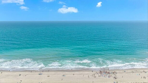 Una spiaggia con acque cristalline e una battigia sabbiosa.
