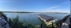 A waterfront view with boats, a covered dock, and a deck with seating.