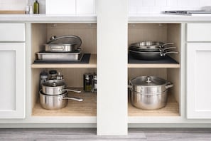 A kitchen with stainless steel cookware, including pots and pans, on open shelves. - Steps to Beach, Eats, ATM, Taxi, Pool View, Golf and Grocery store (Frigate Bay)