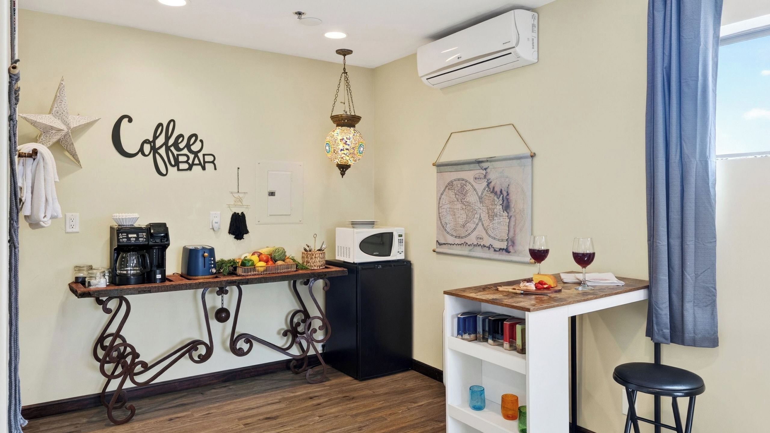 A compact kitchen with a coffee bar, a microwave, and a small dining area with a table and chairs.