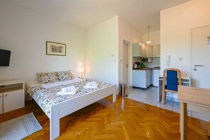 Ein Schlafzimmer mit Bett, Nachttisch und kleinem Schreibtisch mit Stuhl.