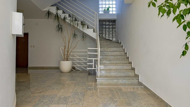 A staircase with a metal railing, a potted plant, and a door at the bottom. - Lucas Apartment A3 in Rovinj (Rovinj)