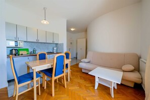Ein kompakter Wohnraum mit Küchenzeile, Essbereich und einer Sitzecke.