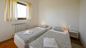 A bedroom with two beds, a window with curtains, a radiator, and bedside lamps. - Lucas Apartment A8 In Rovinj (Rovinj)