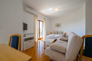 A room with a sofa, a table, a bed, a TV, and a window with curtains. - Lucas studio A9 in Rovinj (Rovinj)