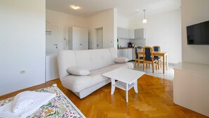 A modern living room with a sofa, a coffee table, and a dining area with chairs and a table. - Lucas studio A9 in Rovinj (Rovinj)
