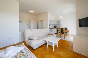 A modern living room with a sofa, a coffee table, and a dining area with chairs and a table. - Lucas studio A9 in Rovinj (Rovinj)