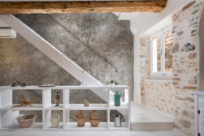 Ein Zimmer mit einer weißen Treppe, einer Betonwand und einem Fenster mit Blick.
