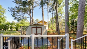 A wooden shed with a door and windows, surrounded by trees and a white fence. - 2 Mi to Bethany Beach: Duplex w/ Private Deck (Bethany Beach)