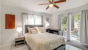 A bedroom with a bed, nightstand, desk, and a view of the outdoors. - 2 Mi to Bethany Beach: Duplex w/ Private Deck (Bethany Beach)