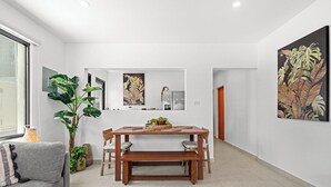 Ein modernes Interieur mit Essbereich, einer Sitzecke und einer großen Pflanze.
