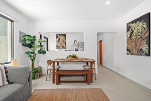 A modern interior with a dining area, a sofa, and a large plant. - Villa Bali: Private Pool | 2 Min Walk to Beach (San Juan)