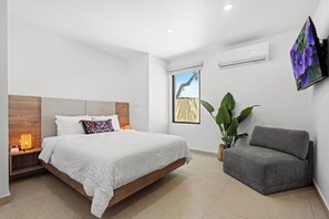 A bedroom with a bed, bedside table, and a grey sofa. - Villa Bali: Private Pool | 2 Min Walk to Beach (San Juan)